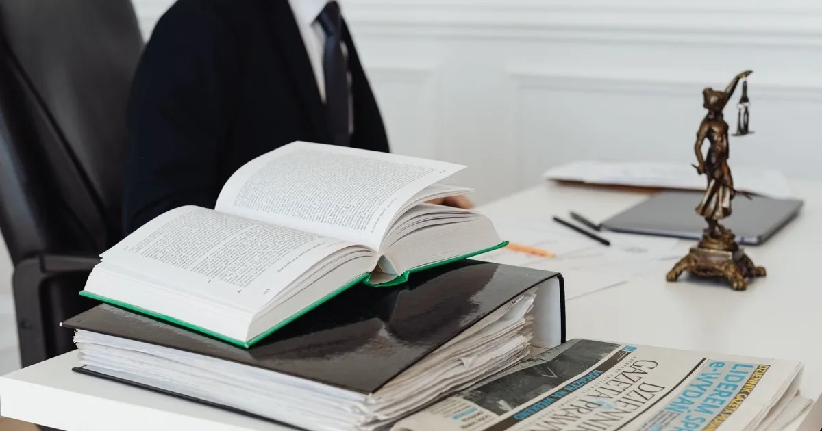 Attorney signing a document at a law office desk Attorney signing a document at a law office desk