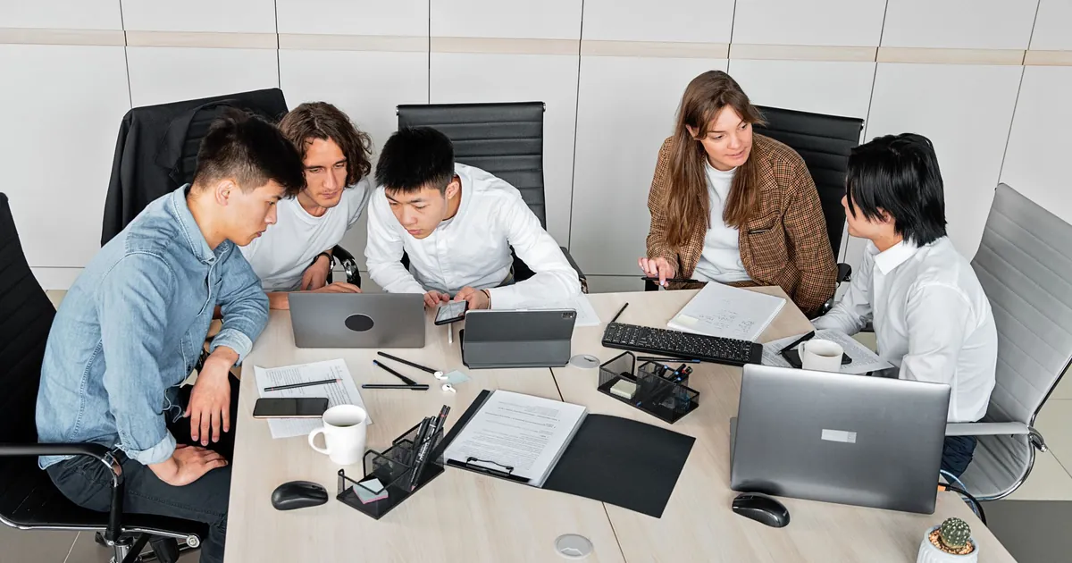 Team working around laptops in a meeting room