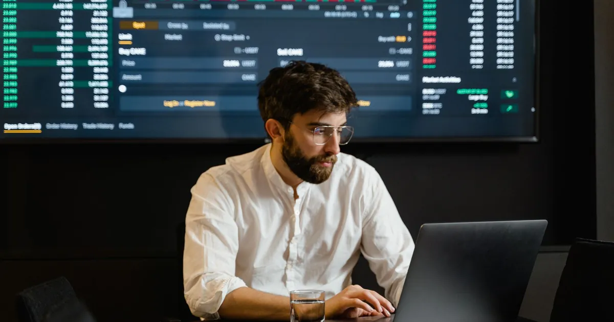 A dense screen is not visibility. A ranked incident is Analyst at a desk with dense screens standing in for a SIEM alert queue