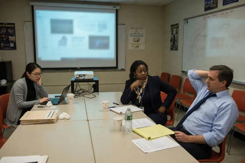 Three adults in a school conference room after the firewall readout