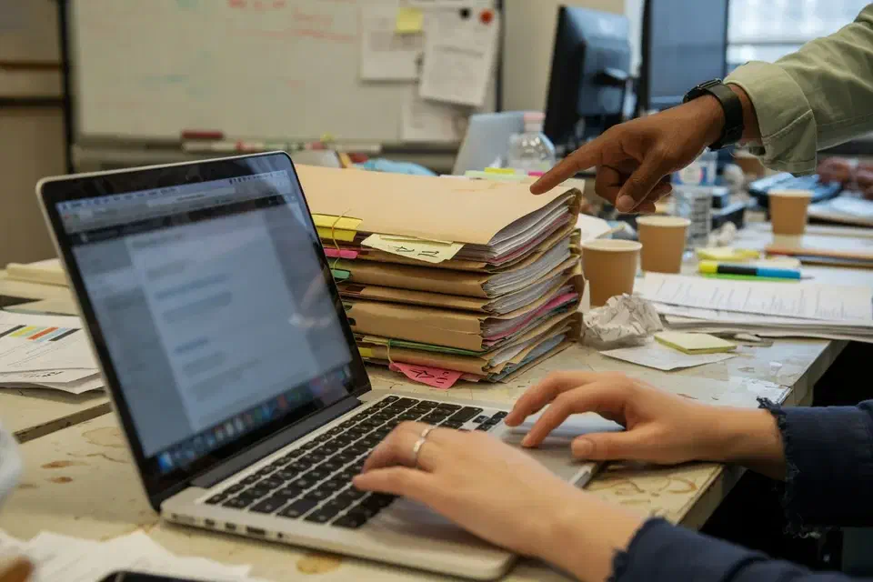 Hands at a laptop in an agency, screen out of focus
