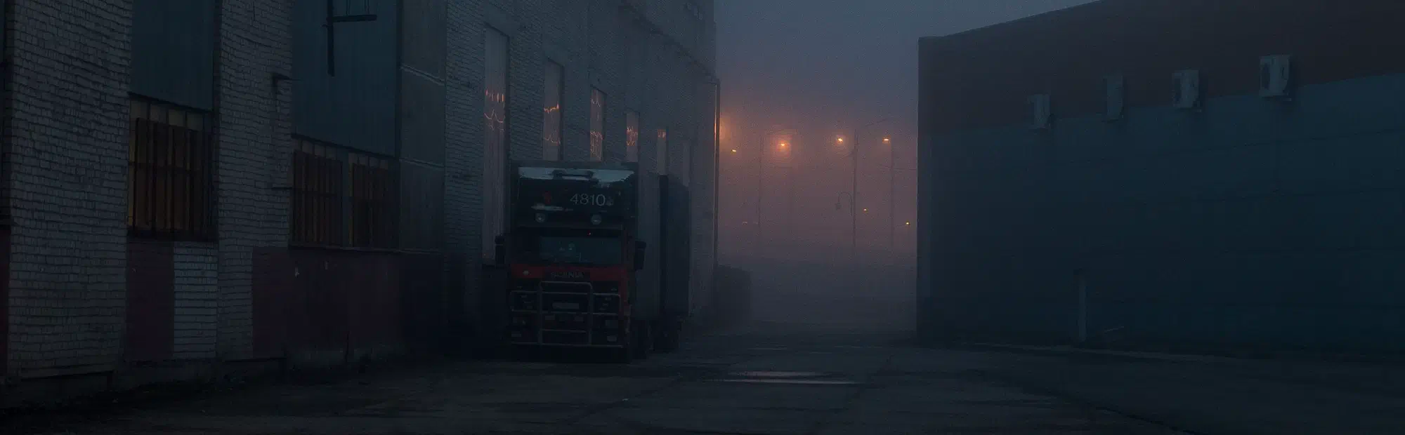 Foggy industrial yard at night, the kind of vulnerable site a mobile CCTV trailer protects